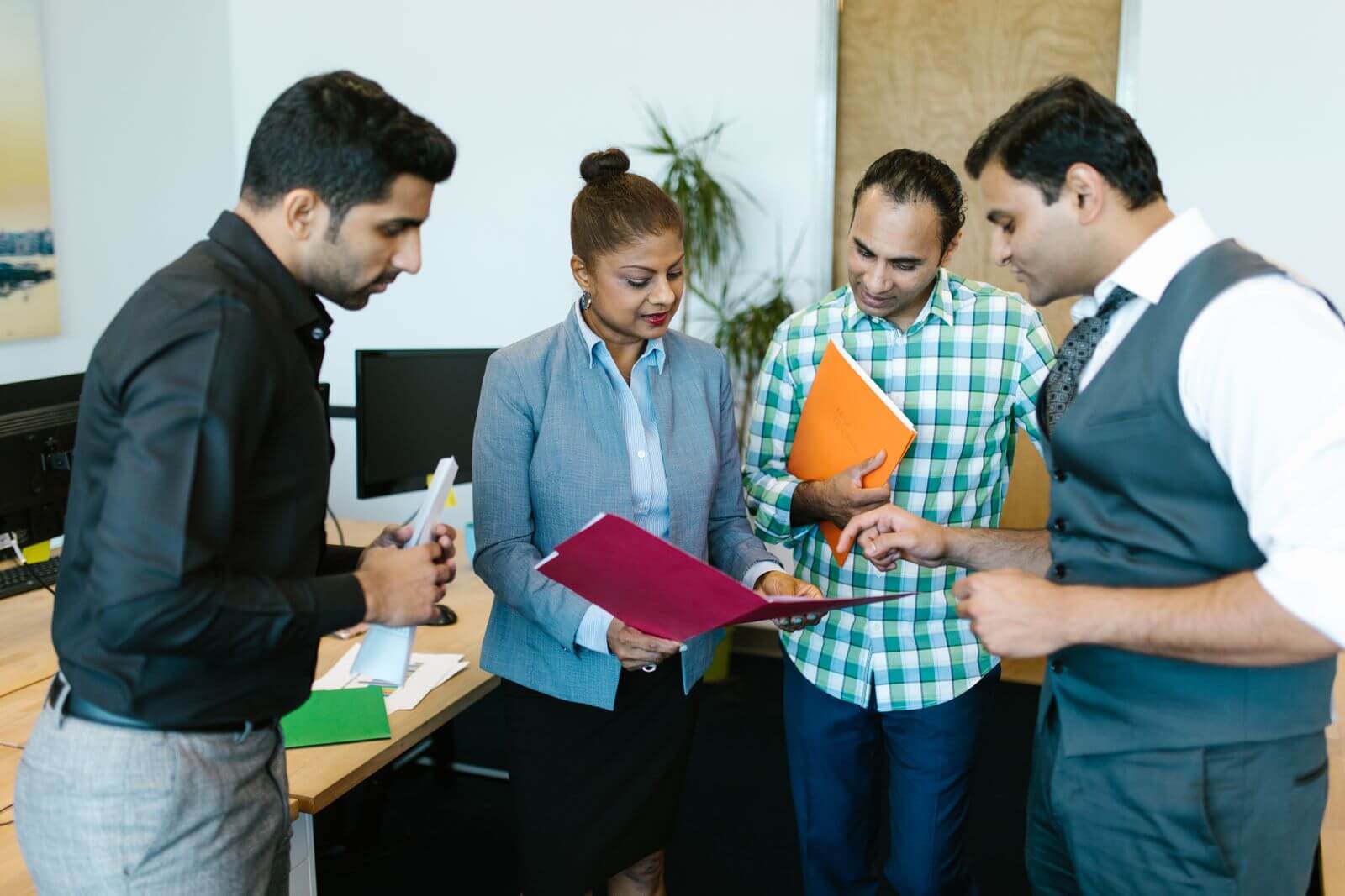 Indian technology professionals discussing a project in a modern office
