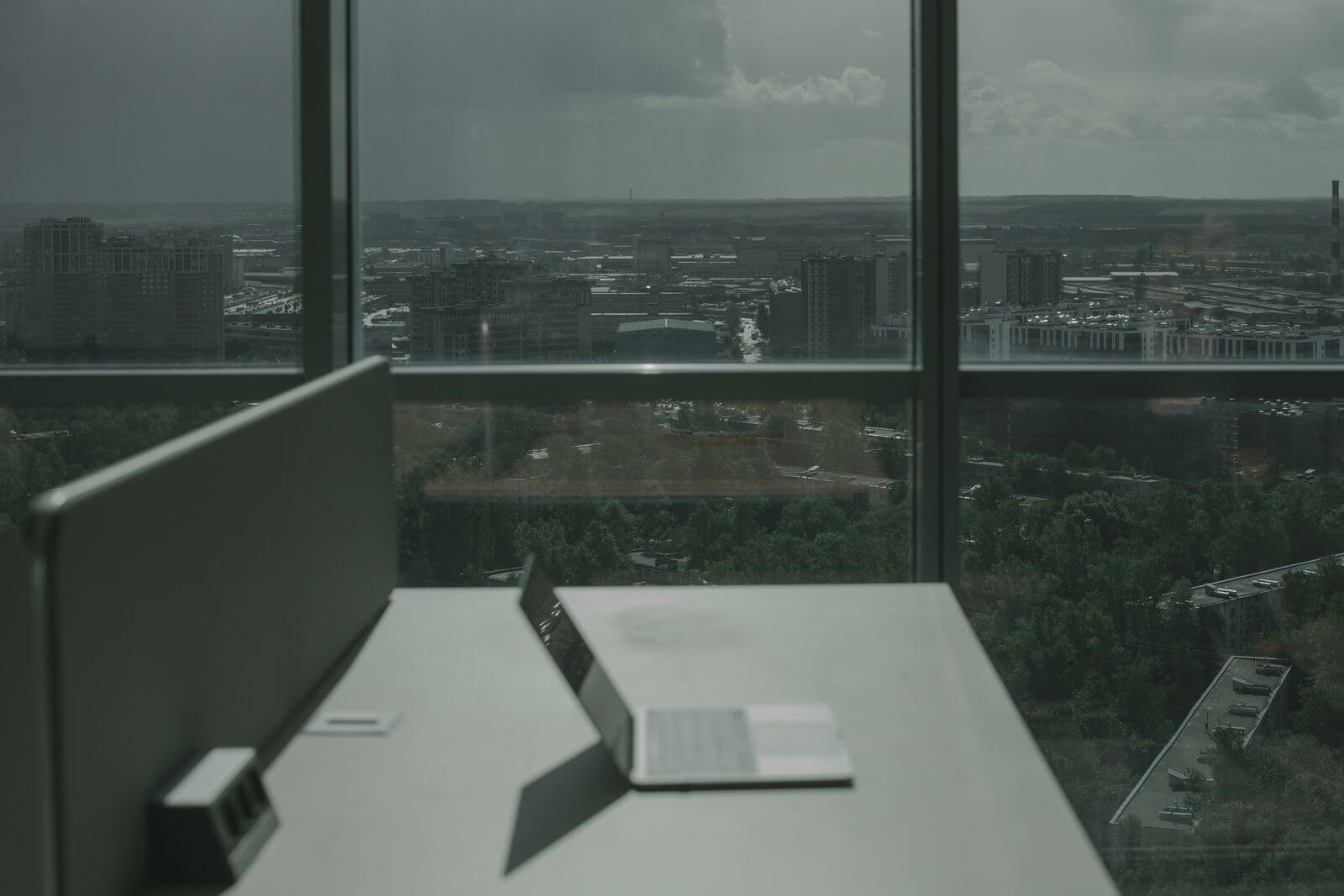Laptop workspace overlooking a broad urban skyline